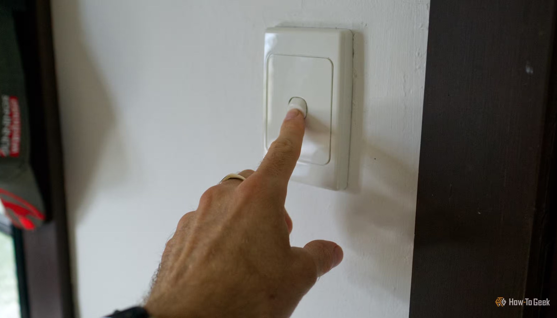 Pressing a dumb light switch to turn on a smart light bulb.