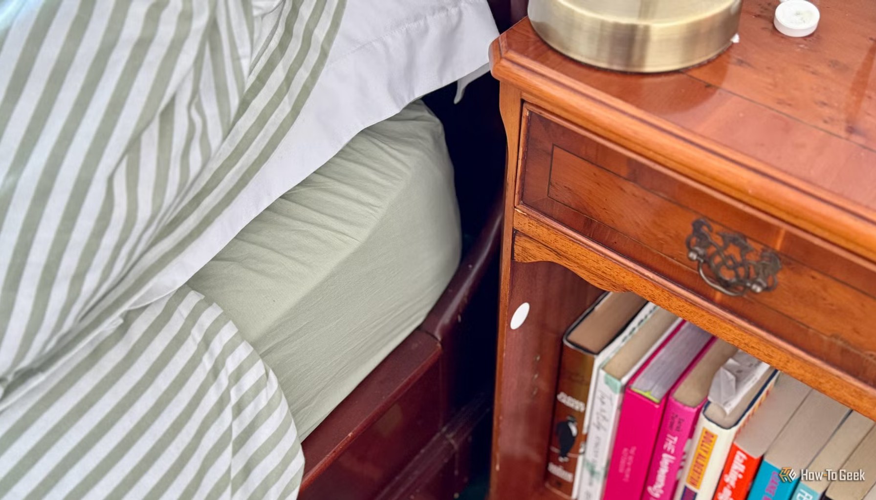 A NFC tag stuck to a nightstand next to a bed.