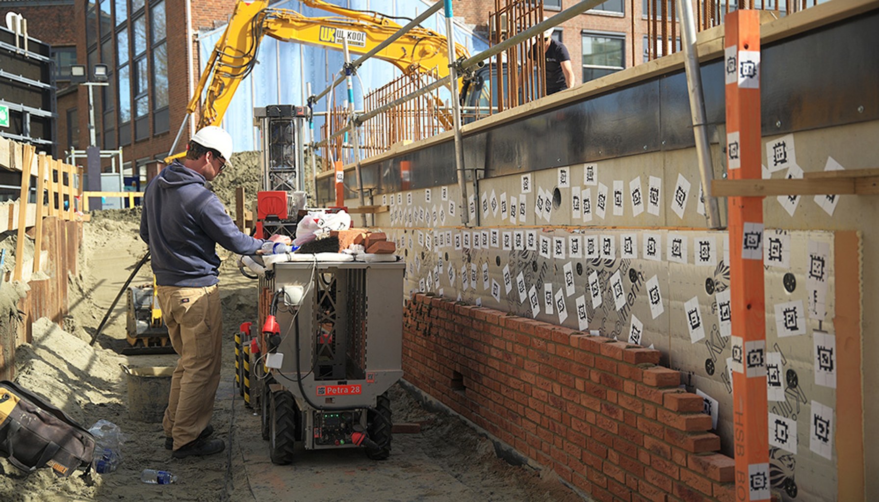 Monumental designs, machines, and maintains robots that lay bricks at construction sites.