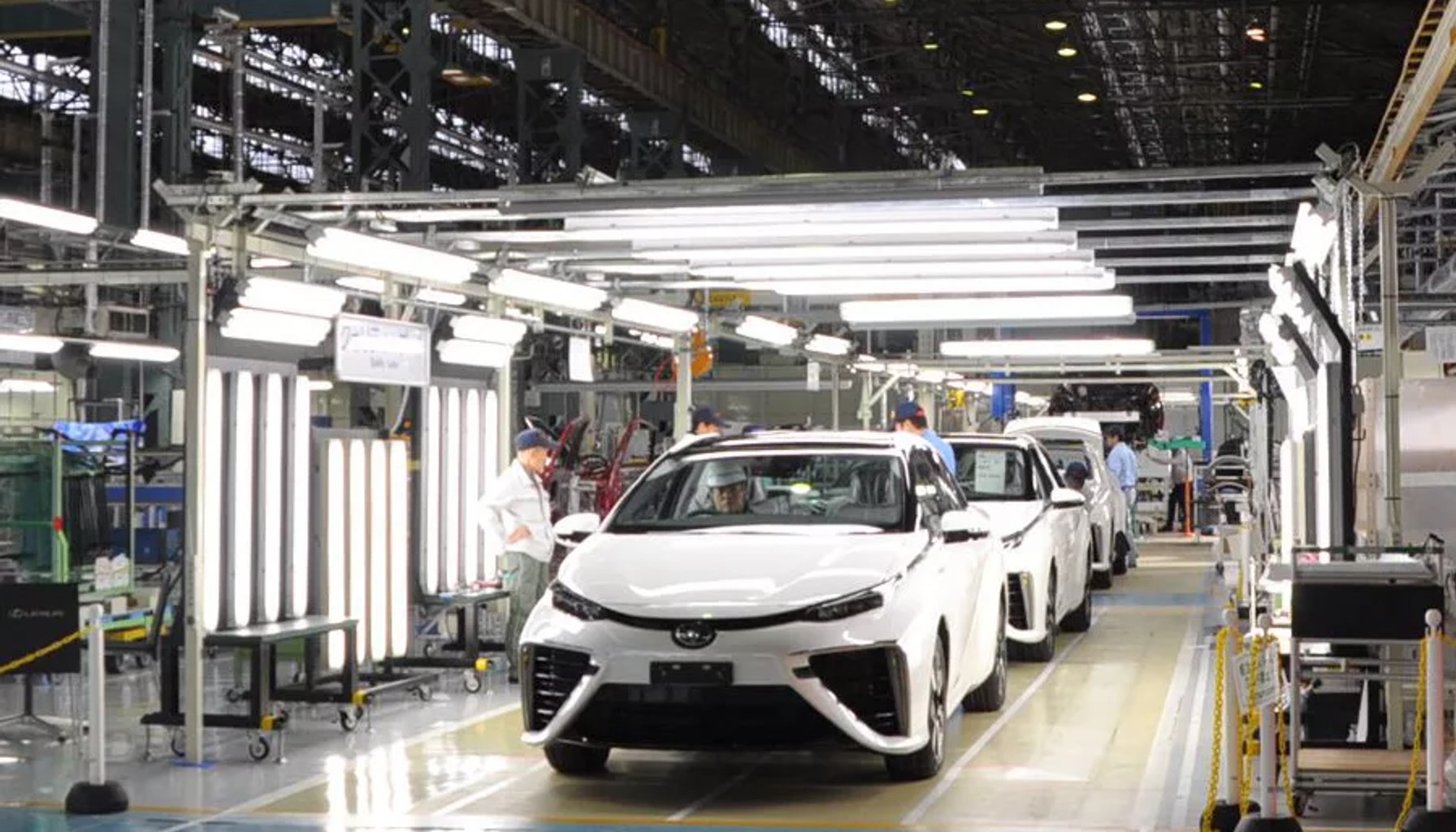 Toyota factory workers assembling vehicles on an automotive production line using advanced manufacturing automation and Factory of the Future technologies in a high-volume assembly plant